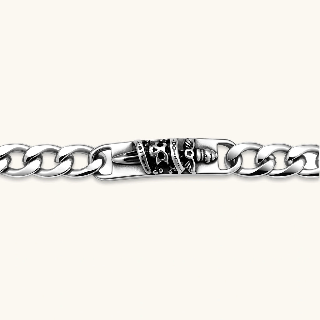 Silver 316L stainless steel Cuban chain bracelet with blackened skull and crown ID bar centerpiece, lobster clasp closure.